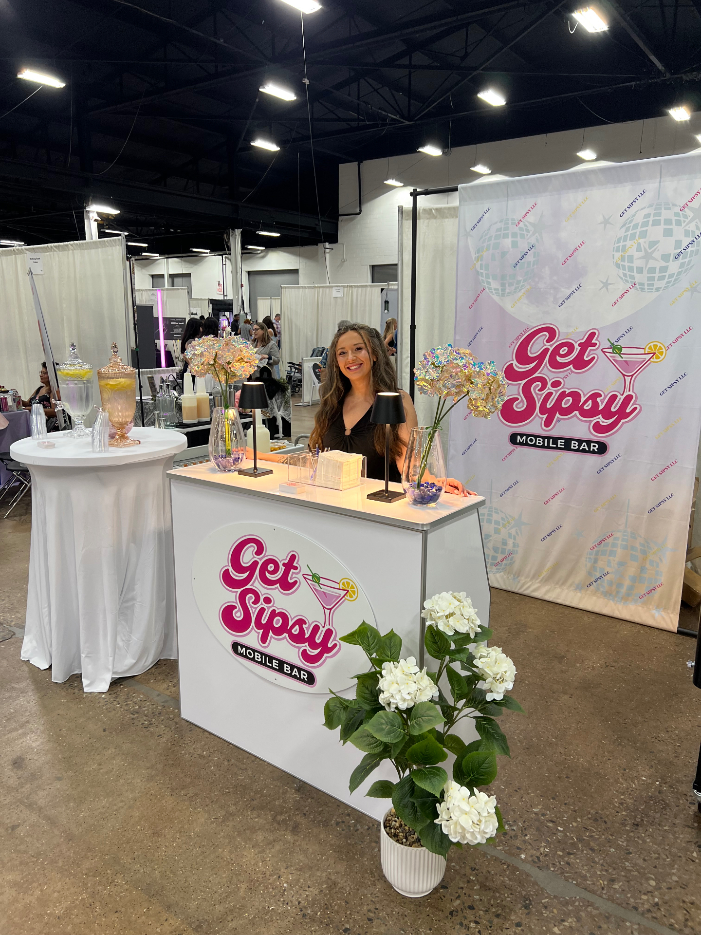 Get Sipsy bartender at the mobile bar booth with branded backdrop at an expo