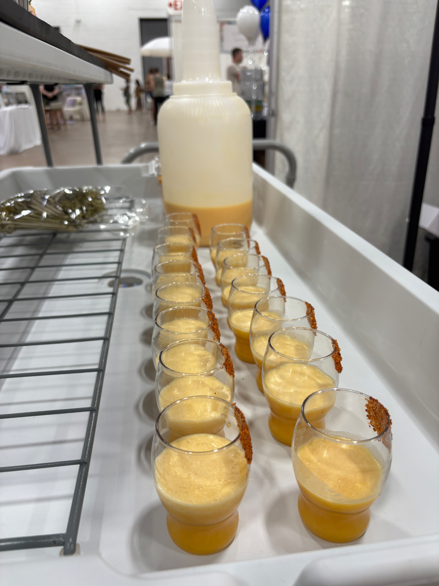 Row of signature mango shots with chili-salt rim ready to serve